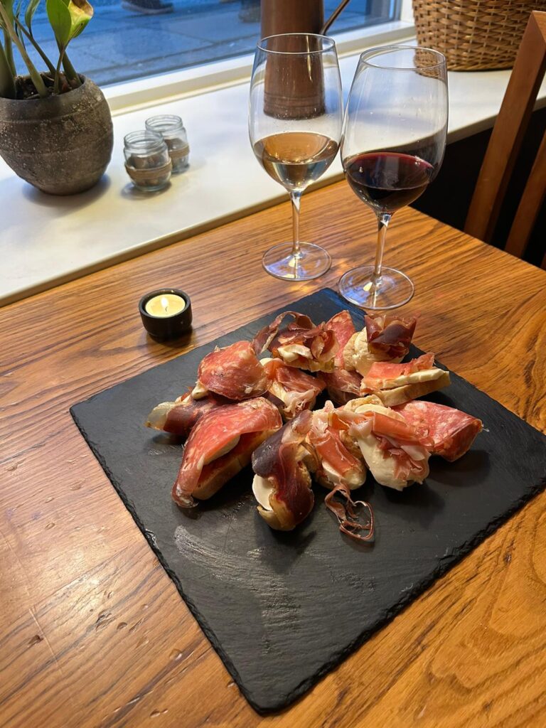 Tapas med skinke og vin på restaurantbord